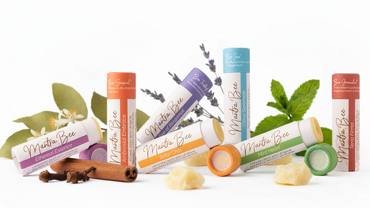 Various lip balm tubes with 'Mantra Bee' branding with botanicals