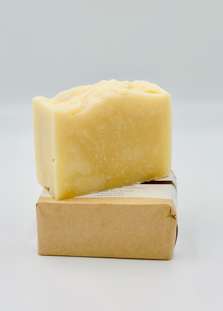 Bar of shampoo soap on a paper wrapping against a gray background