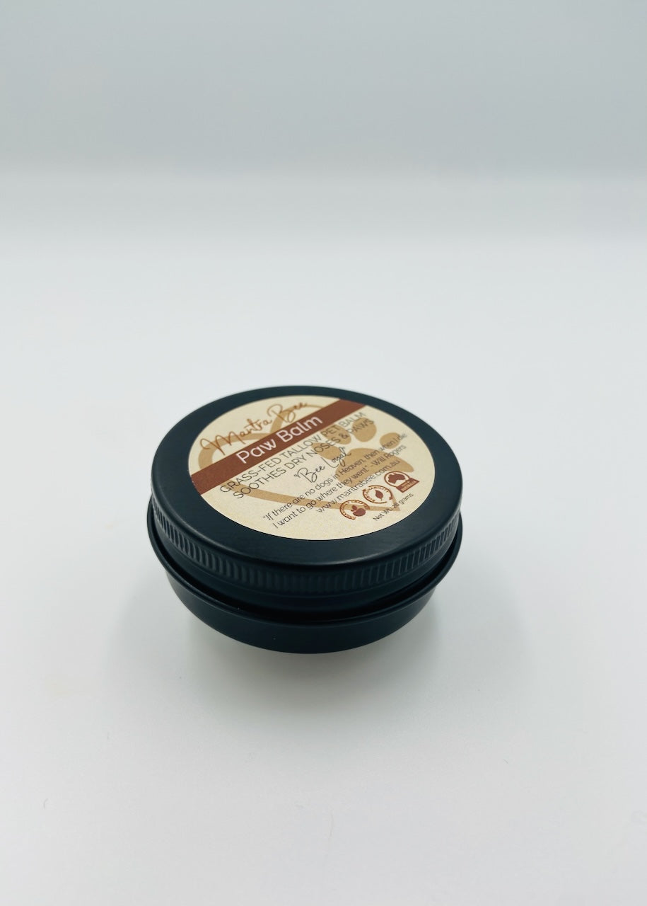 Tin of paw balm with a black lid on a white background